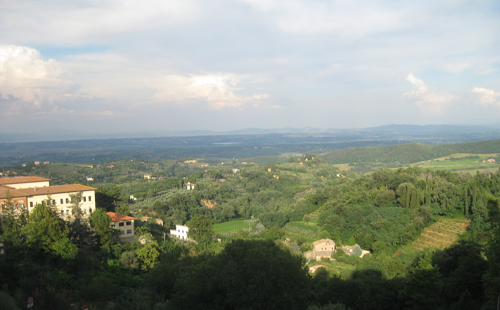 Weite Hügellandschaft bei Montepulciano unter hellem Himmel