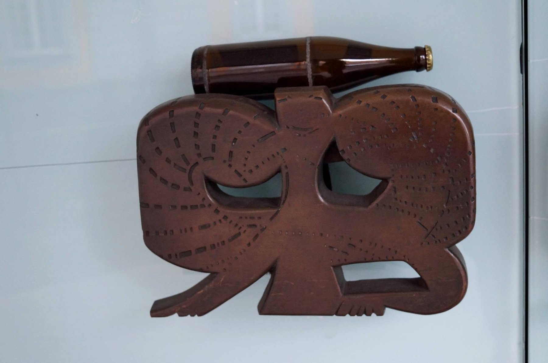 Geschnitzte Elefantenfigur mit einer liegenden Flasche auf dem Rücken