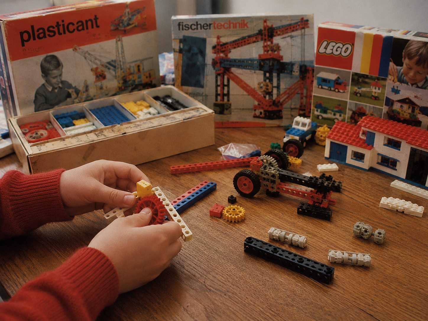 Rekonstruiertes Erinnerungsbild mit Plasticant, Fischertechnik und Lego auf einem Kindertisch